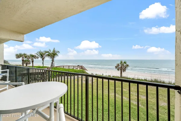 a view of a balcony with wooden floor & fence