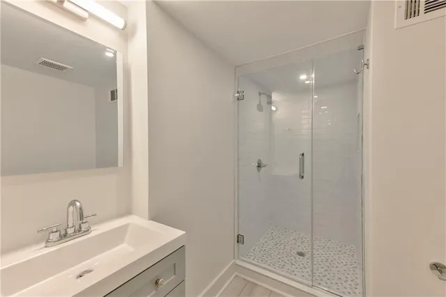 a bathroom with a shower sink vanity and mirror