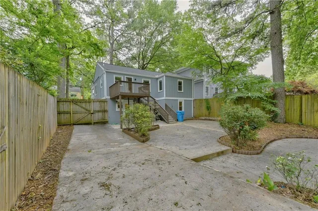 a view of a house with a yard and large tree