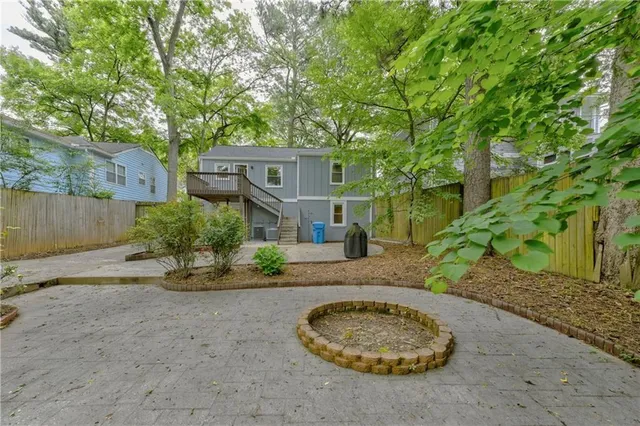 a view of a house with a small yard and a large tree