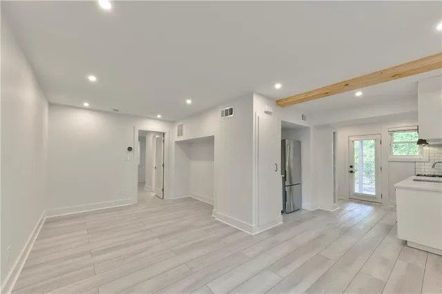 a view of a big room with wooden floor and windows
