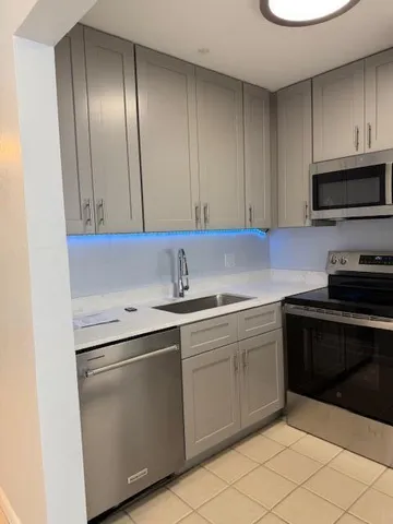 a kitchen with stainless steel appliances granite countertop a sink stove and cabinets