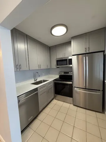 a kitchen with granite countertop stainless steel appliances and a refrigerator