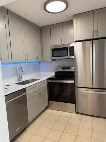 a kitchen with granite countertop a refrigerator and a sink