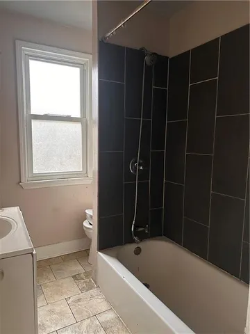 a bathroom with a bathtub a window and a shower