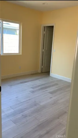 an empty room with wooden floor and a window