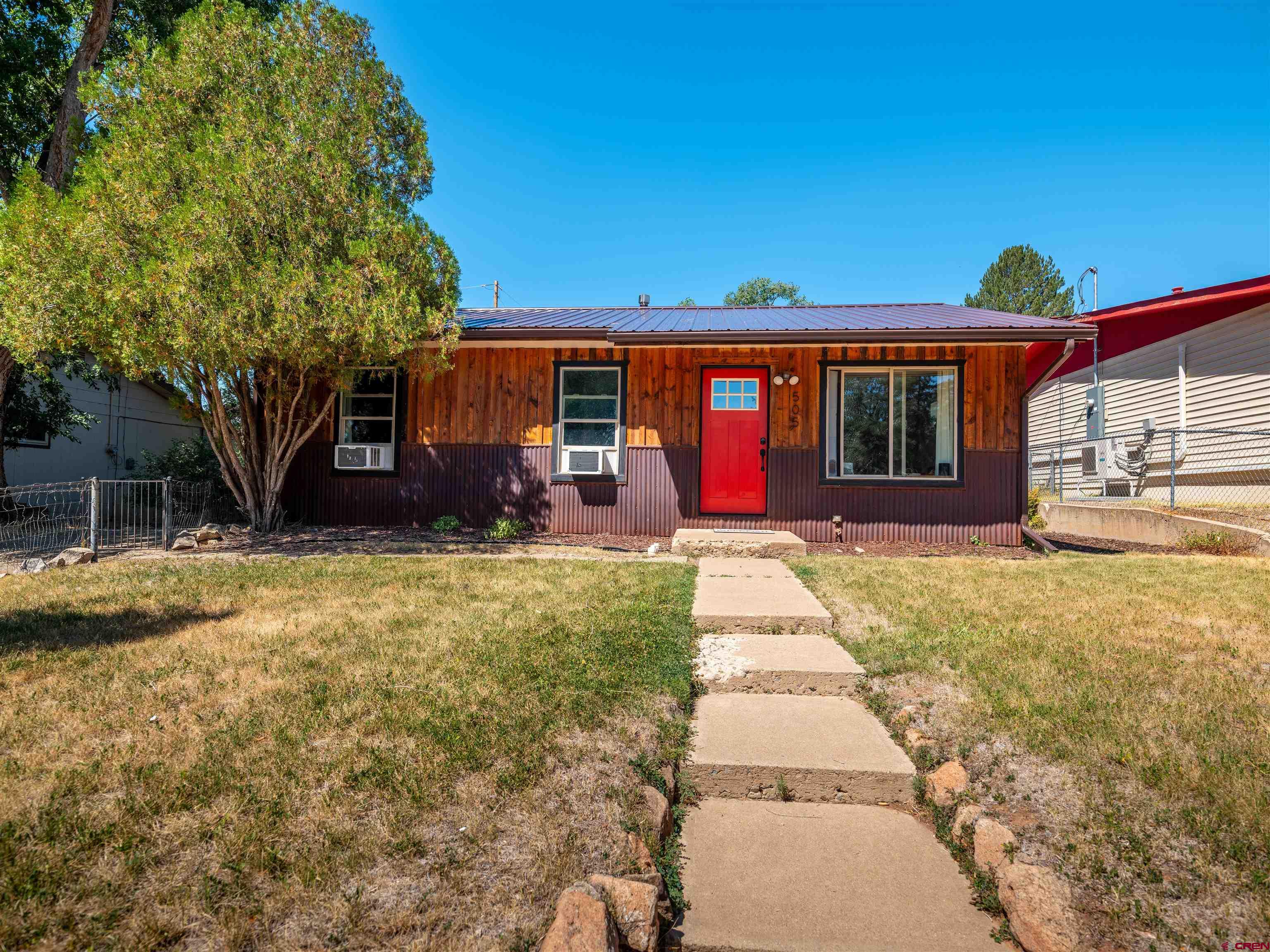 505 South Valley Road Cortez, CO 81321 - Photo 2 of 27 a front view of a house with a yard and potted plants