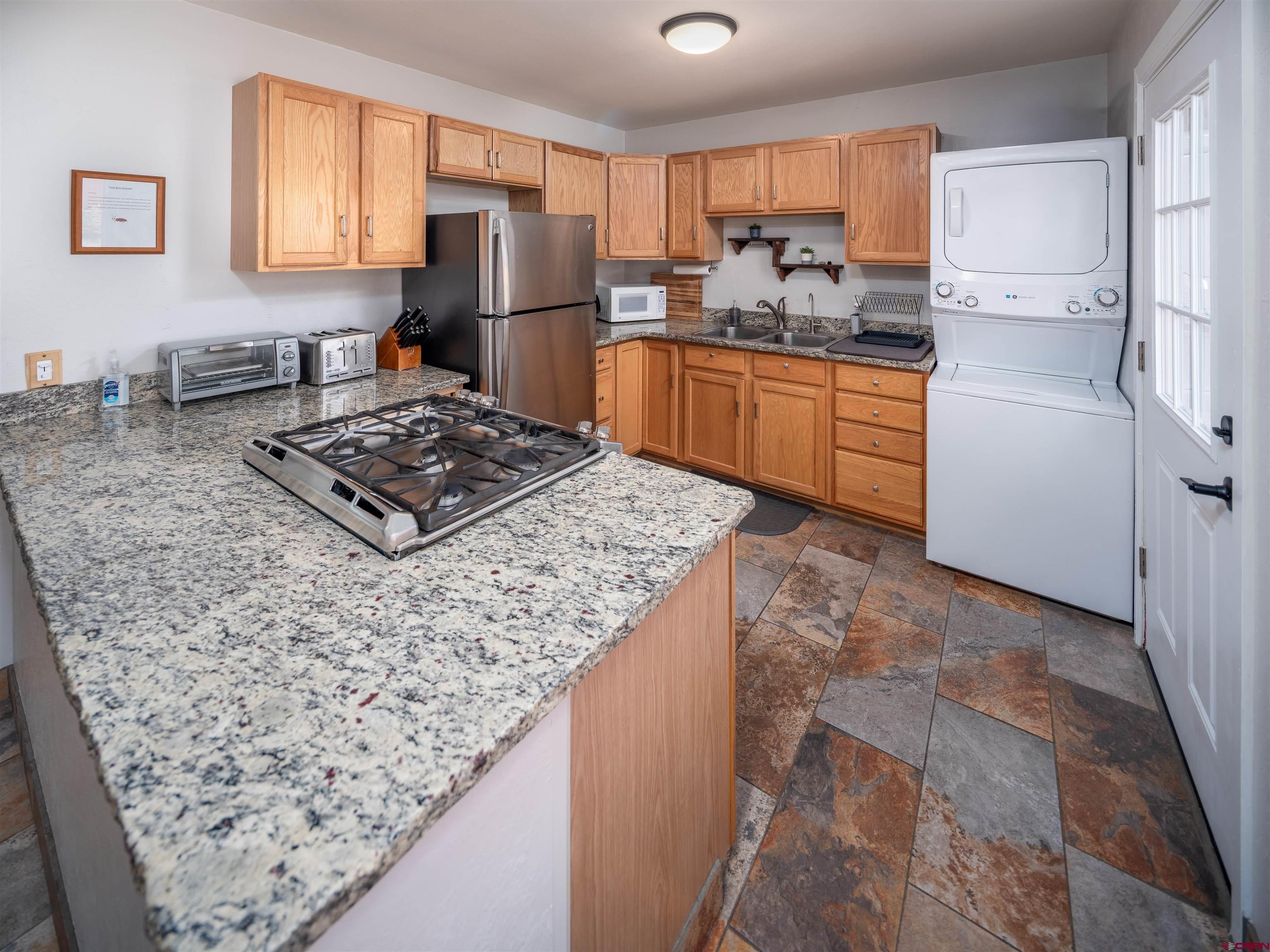 505 South Valley Road Cortez, CO 81321 - Photo 8 of 27 a kitchen with stainless steel appliances granite countertop a refrigerator stove sink and a window