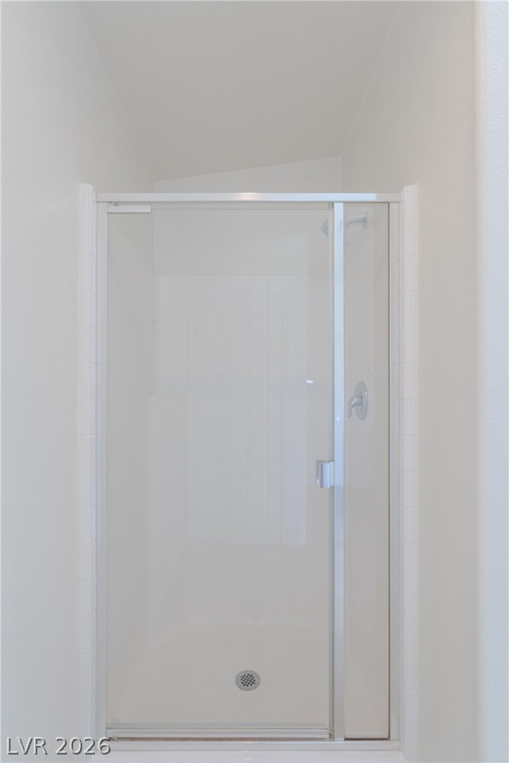 8079 Buffalo Ranch Avenue Las Vegas, NV 89147 - Photo 21 of 29 A framed glass walk-in shower features classic tile surround and chrome hardware.
