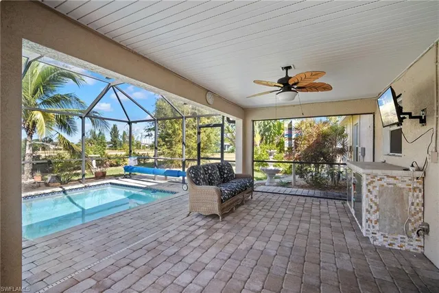 a living room with furniture a flat screen tv and a floor to ceiling window