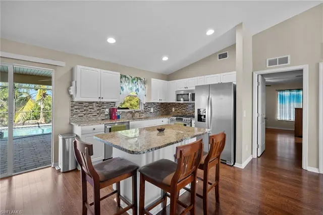 a dining room with stainless steel appliances a table and chairs