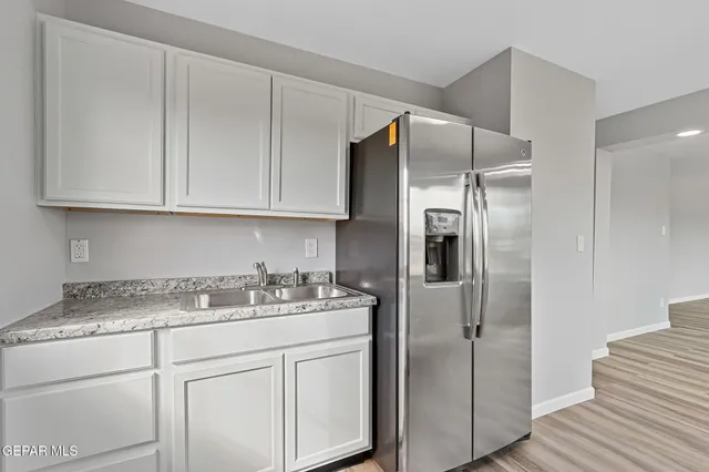 a view of a big room with wooden floor and windows