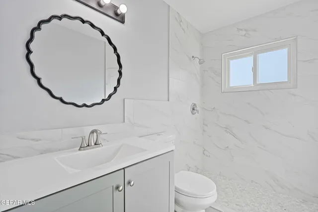 an aerial view of a city with lots of residential buildings and mountain view in back