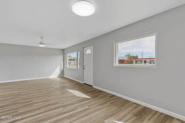 a kitchen with a window wooden floor and stainless steel appliances