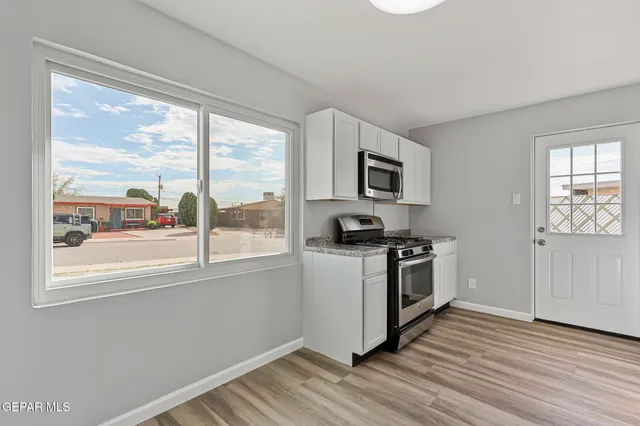 a kitchen with granite countertop white cabinets and sink