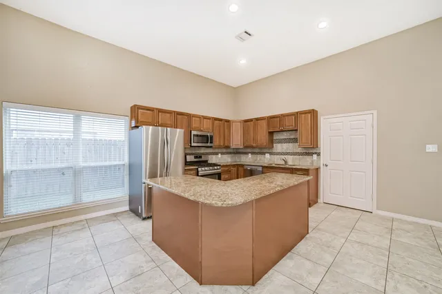 a kitchen with stainless steel appliances granite countertop a refrigerator and a stove