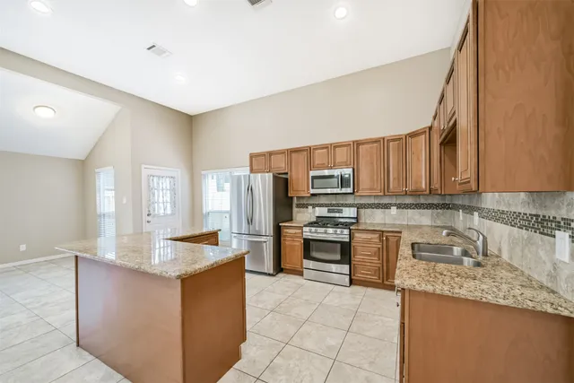 a kitchen with stainless steel appliances granite countertop a sink and a white cabinets