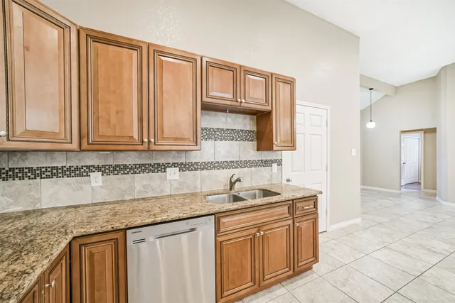 a kitchen with granite countertop a refrigerator stove and microwave