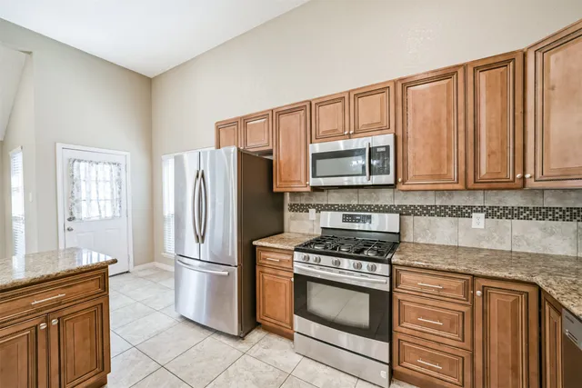 a kitchen with stainless steel appliances granite countertop a stove top oven microwave and cabinets