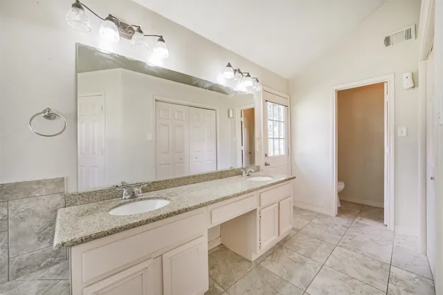 a view of an empty room with a chandelier fan