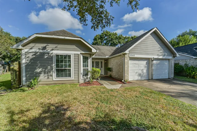 a view of a house with a yard and potted plants