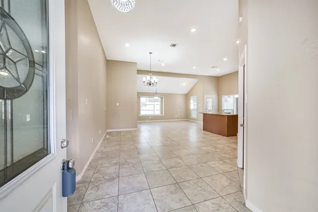 a view of a hallway with wooden floor and a bathroom