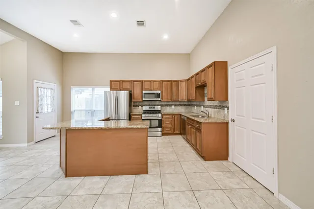 a large kitchen with stainless steel appliances lots of counter top space