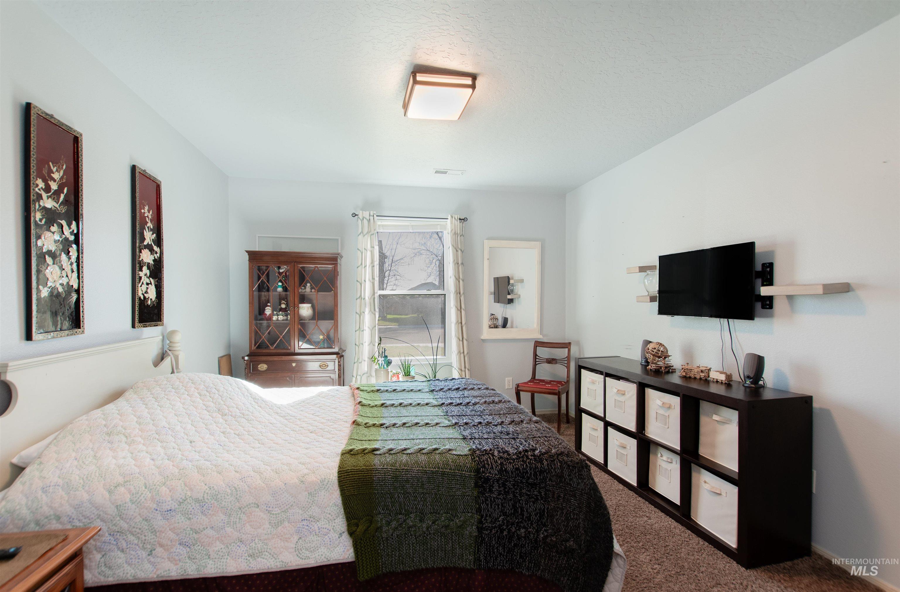 16711 Abram Avenue Caldwell, ID 83607 - Photo 15 of 24 Bedroom featuring dark carpet and a textured ceiling