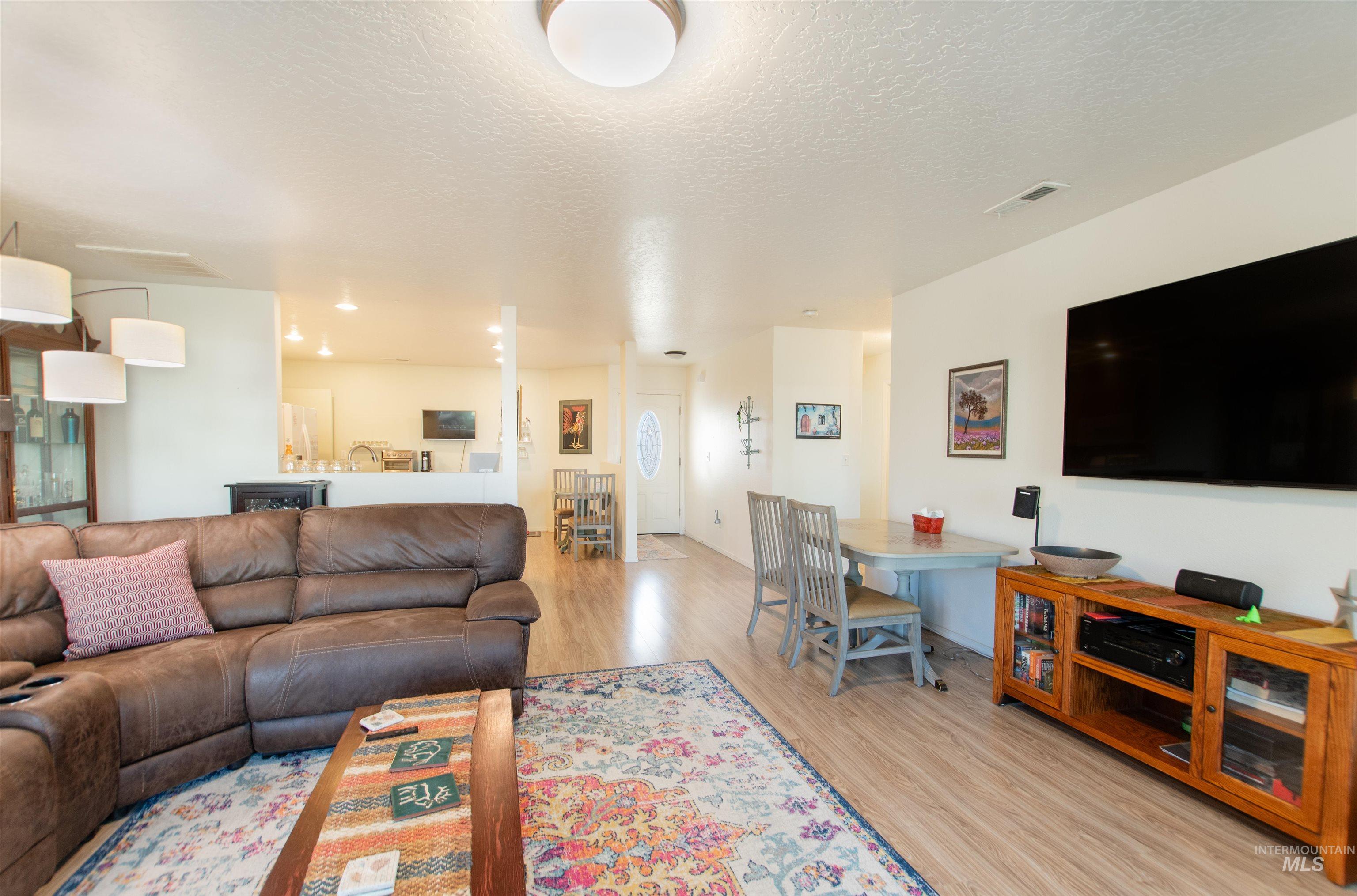 16711 Abram Avenue Caldwell, ID 83607 - Photo 10 of 24 Living room with a textured ceiling and light wood finished floors