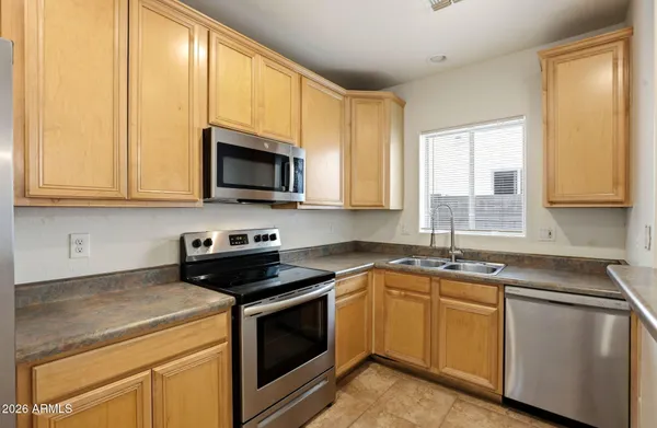 a kitchen with granite countertop white cabinets sink and stainless steel appliances