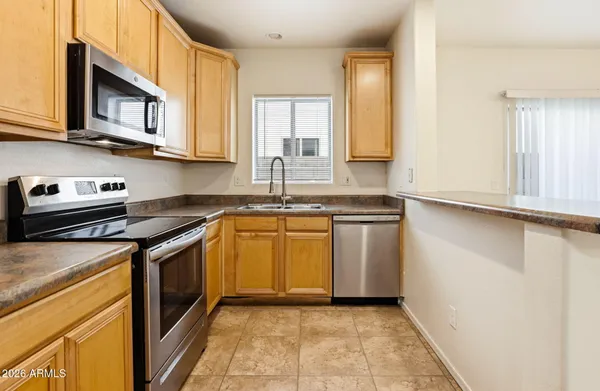 a kitchen with stainless steel appliances granite countertop a stove a sink and a microwave