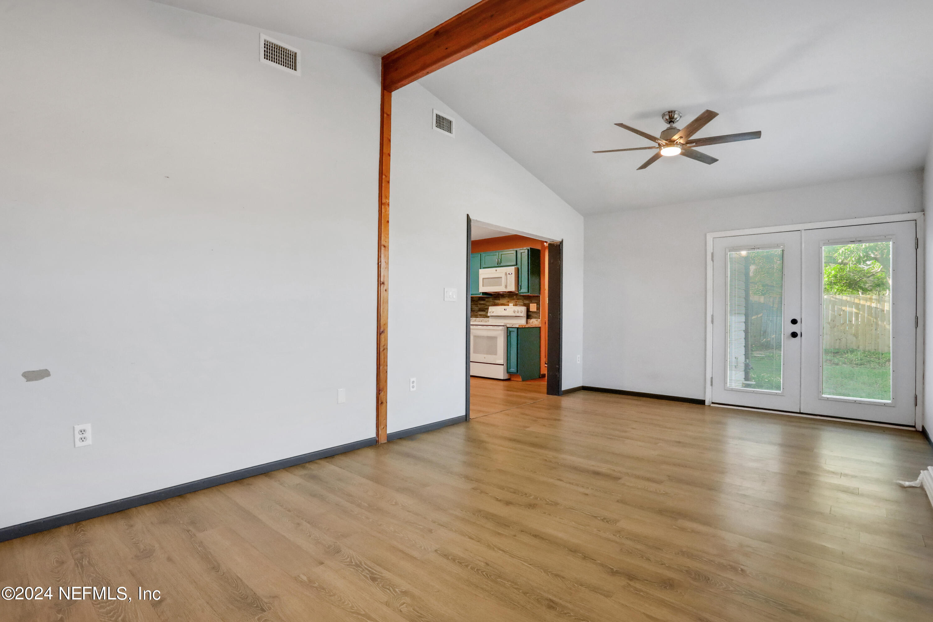 230 Cornell Road St. Augustine, FL 32086 - Photo 2 of 32 an empty room with wooden floor chandelier fan and windows
