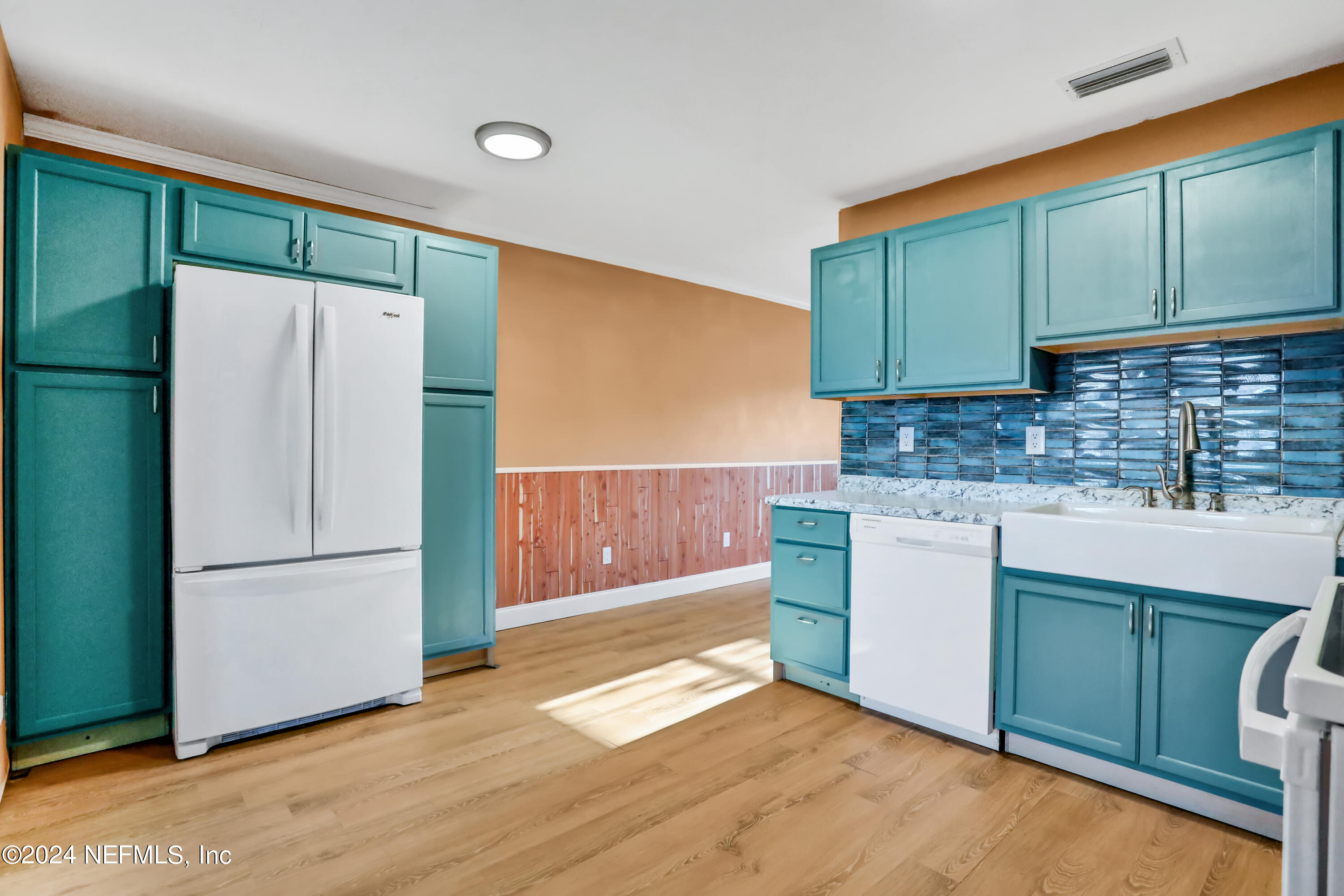 230 Cornell Road St. Augustine, FL 32086 - Photo 6 of 32 a kitchen with kitchen island a refrigerator sink and cabinets