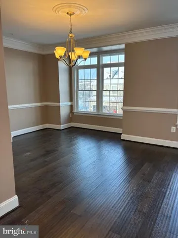 a kitchen with stainless steel appliances granite countertop a sink and a white cabinets with wooden floor