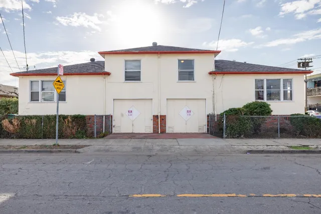 a view of a white house next to a road