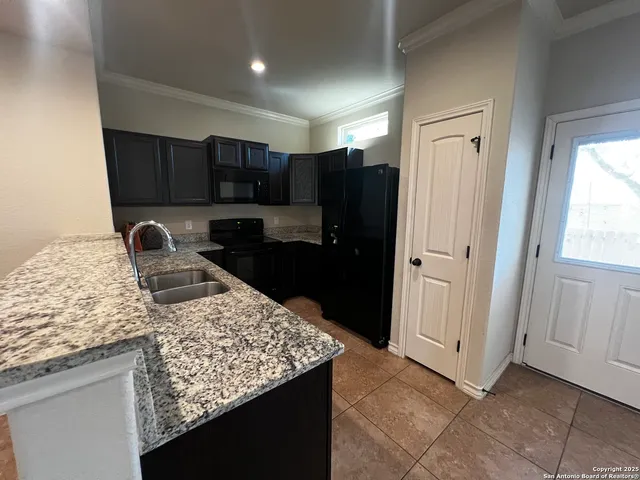 a kitchen with granite countertop a refrigerator and a stove