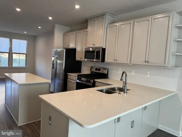 a kitchen with stainless steel appliances a refrigerator sink and microwave