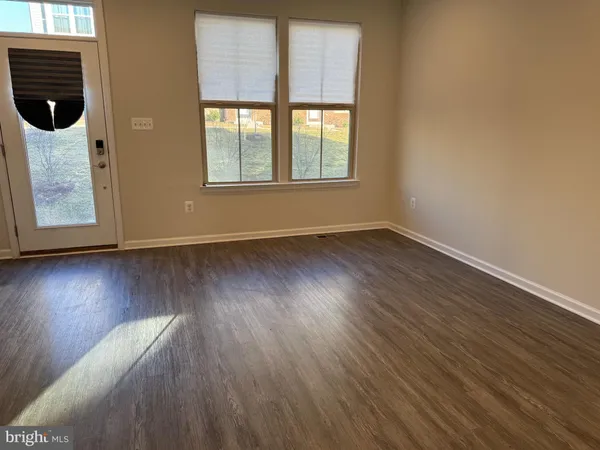 a view of a room with wooden floor and windows