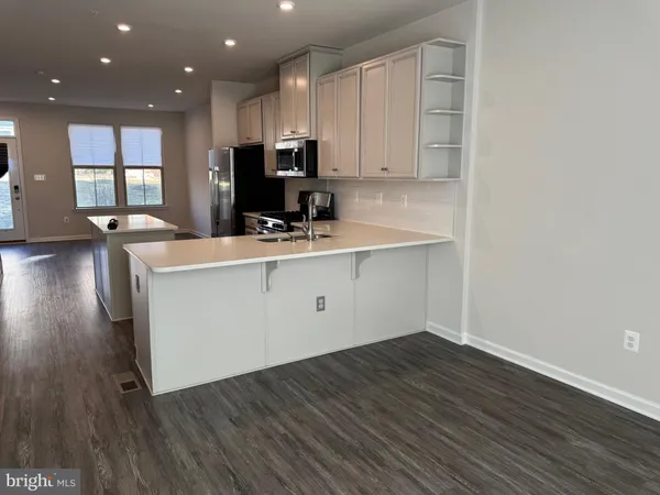 a view of a kitchen with center island and wooden floor