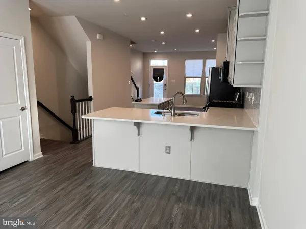a view of a kitchen with cabinets stainless steel appliances and wooden floor