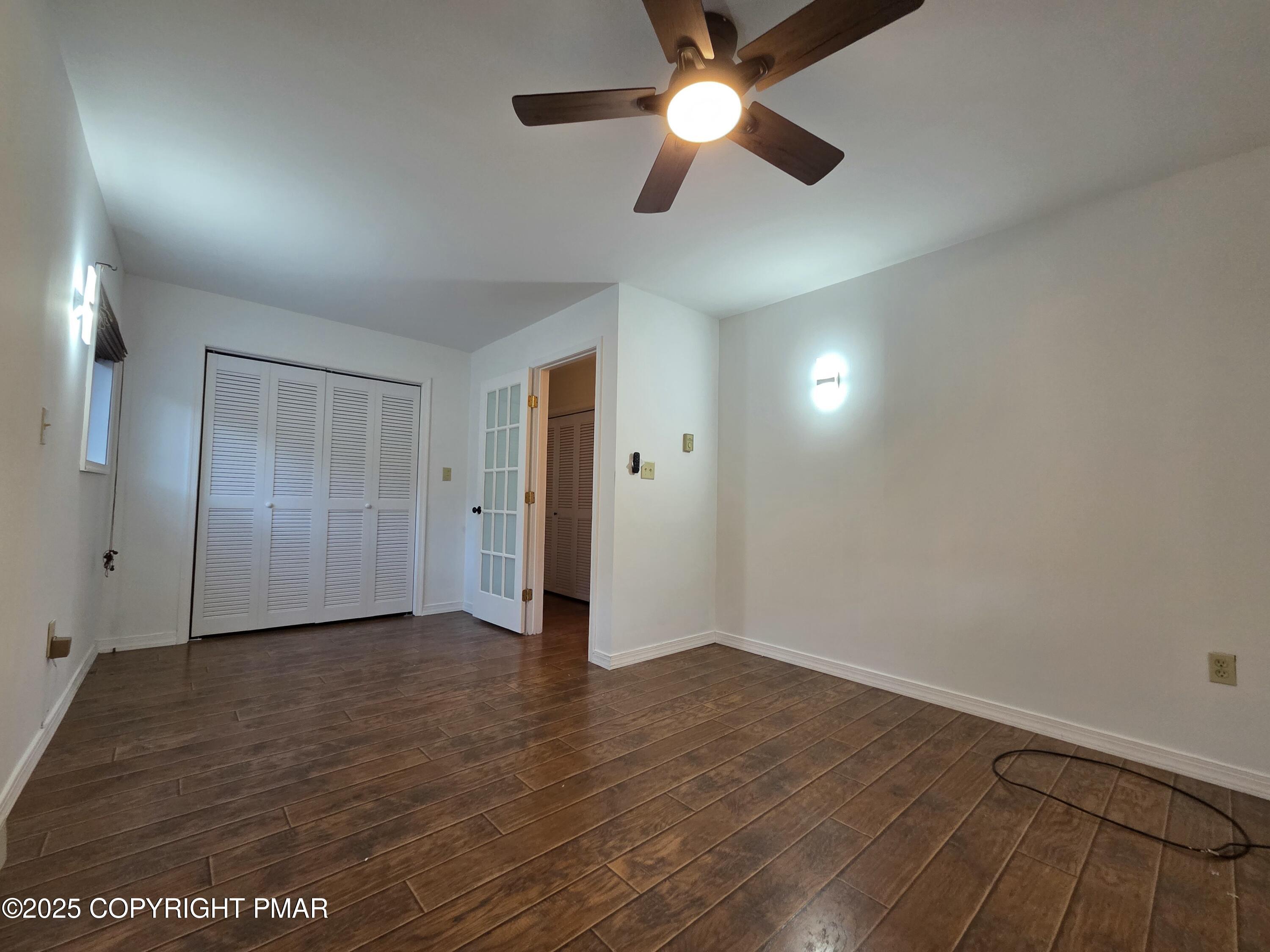 107 Berkshire Court Bushkill, PA 18324 - Photo 9 of 16 an empty room with wooden floor and windows