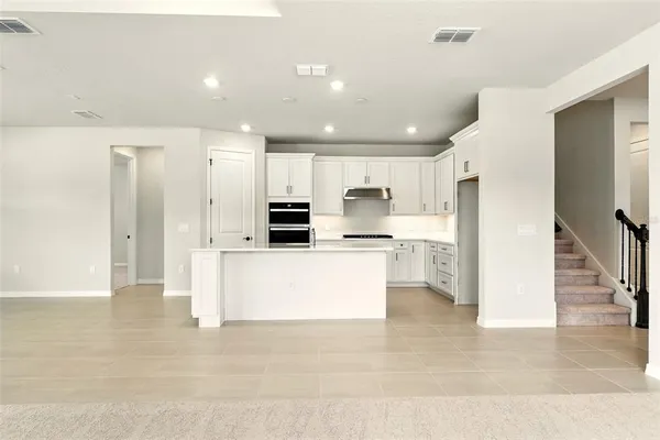 a large white kitchen with stainless steel appliances