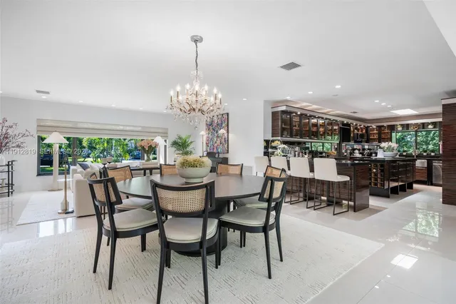 a dining room with furniture a chandelier and pool table