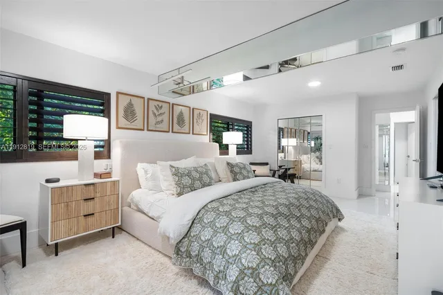 a bedroom with a bed and lamp on dresser