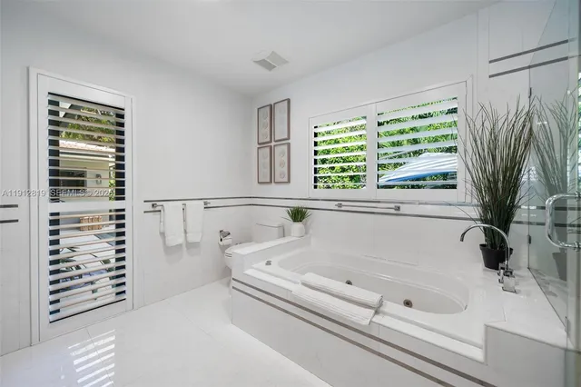 a bathroom with bathtub next to a window