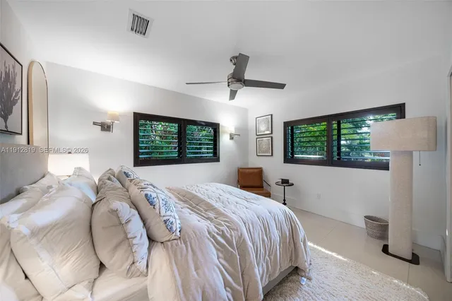 a bedroom with a bed window and a flat screen tv