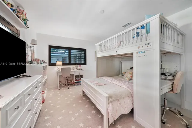a bedroom with a bed window and a flat screen tv