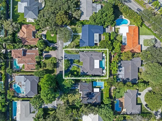 an aerial view of residential houses with outdoor space and trees