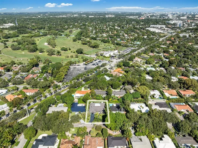 a view of a backyard with potted plants and large trees