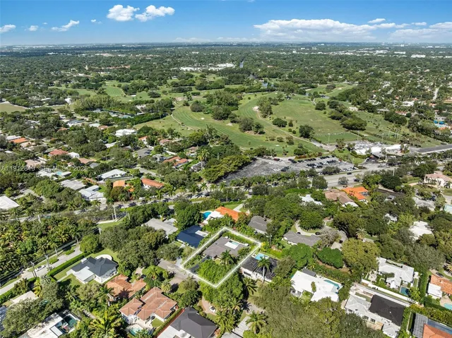 an aerial view of a city with lots of residential buildings ocean and mountain view in back